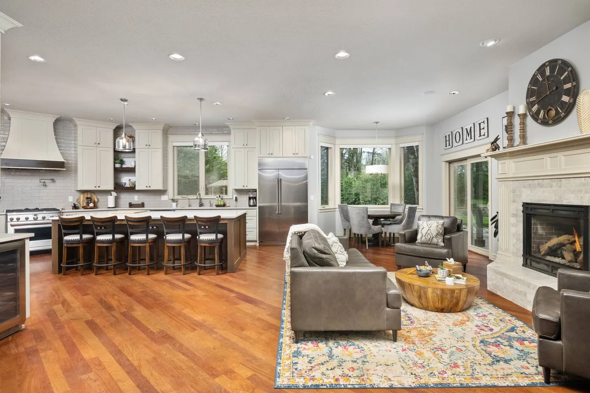 An open-plan kitchen and dining area with a large quartz island, visible fireplace, and stylish dining space. The room exudes warmth with its welcoming decor and offers ample space for cooking, entertaining, and sharing meals.